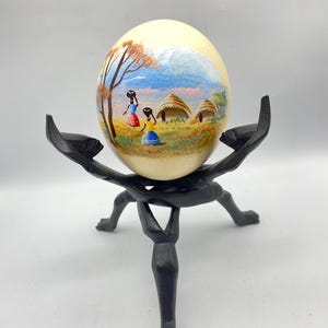 African Ostrich Egg Hand Painted Women in Village Scene With Carved Wooden Stand Vintage