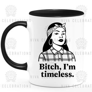 May include: White ceramic mug with a black handle and rim. The mug features a black and white illustration of a woman wearing a bandana and hoop earrings. The text "Bitch, I'm timeless" is printed below the illustration.