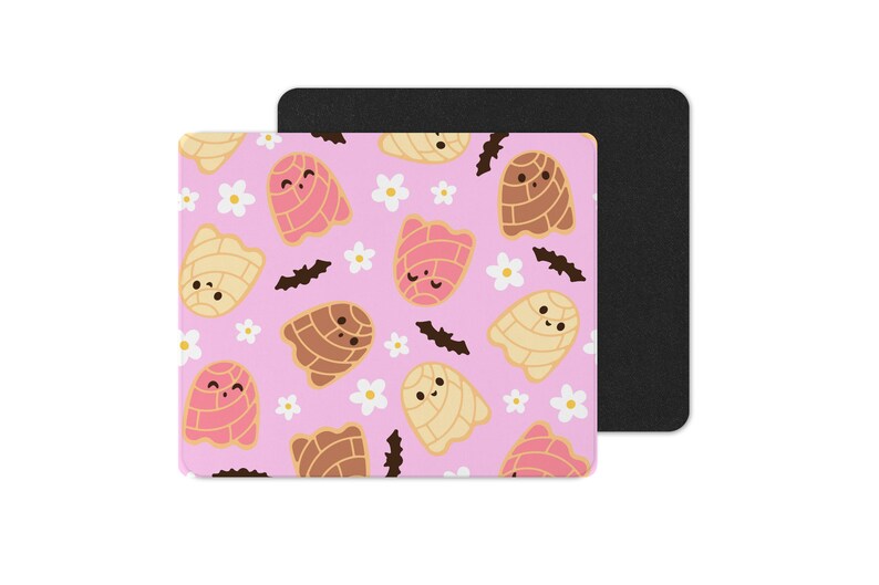 Puede incluir: Un mousepad rosa con un patr&oacute;n repetido de pan concha de dibujos animados, flores blancas y murci&eacute;lagos negros. Las conchas son en tonos de rosa, marr&oacute;n y amarillo. Una almohadilla rectangular negra est&aacute; detr&aacute;s de la almohadilla estampada.