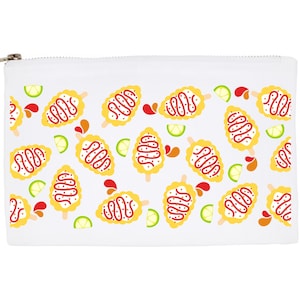May include: White zippered pouch featuring a repeating pattern of yellow corn on the cob popsicles with red drizzle, lime wedges, and red droplets. The pouch has a silver zipper and is likely used for cosmetics or small items.