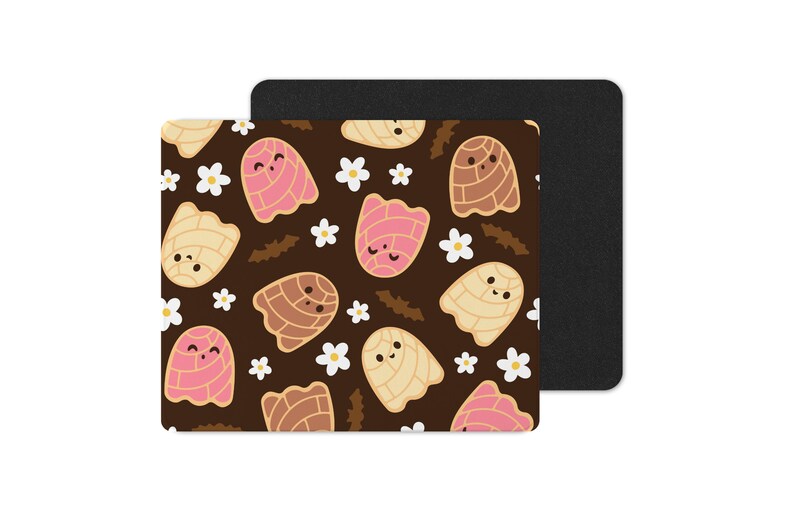 Puede incluir: Una alfombrilla de rat&oacute;n rectangular con un fondo marr&oacute;n que presenta un patr&oacute;n de pasteles de concha de dibujos animados en rosa, beige y marr&oacute;n, junto con flores blancas. Una alfombrilla de rat&oacute;n negra est&aacute; detr&aacute;s.