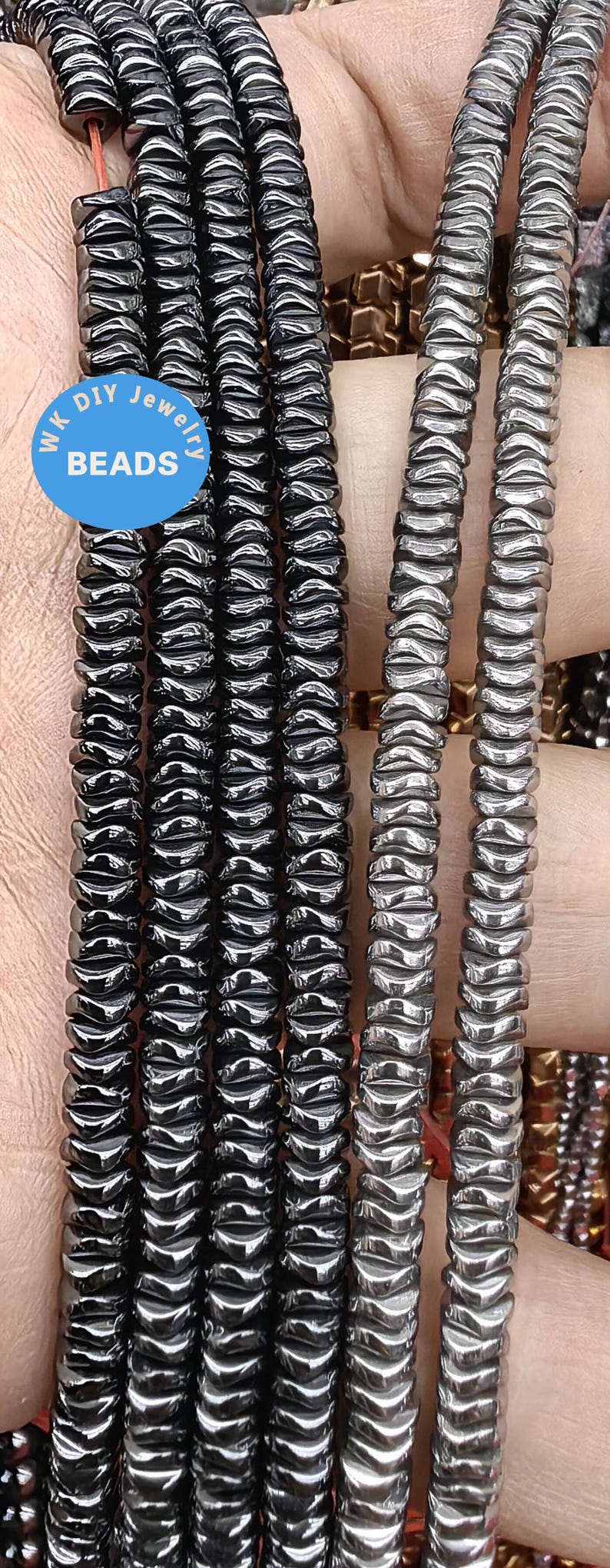 May include: A close-up of a strand of black hematite beads. The beads are faceted and have a shiny finish. The beads are strung on a cord and are ready to be used for jewelry making.