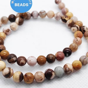May include: A strand of brown, white, and pink agate beads. The beads are round and have a natural, polished finish.