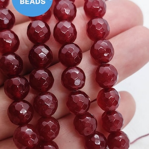 以下が含まれることがあります： 深紅色のファセットカットされた宝石ビーズのストランド。ビーズは丸く、滑らかで磨かれた仕上げになっています。WK DIY Jewelry Beads.