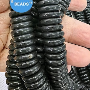 Könnte beinhalten: Eine Schnur aus schwarzen, runden, glatten und glänzenden Perlen. Die Perlen sind spiralförmig übereinander gestapelt. Die Perlen haben einen Durchmesser von etwa 1,2 cm. WK DIY Jewelry Beads.