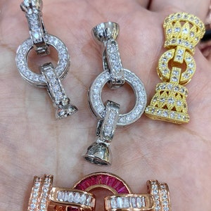May include: Three different styles of silver and gold tone clasps with clear crystal embellishments. The clasps are designed for jewelry making.