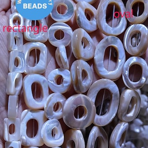 May include: A strand of white and beige shell beads with different shapes, including round, oval, and rectangular. The beads have a hole in the center and are strung on a clear thread. The beads are labeled "round", "oval", and "rectangle".