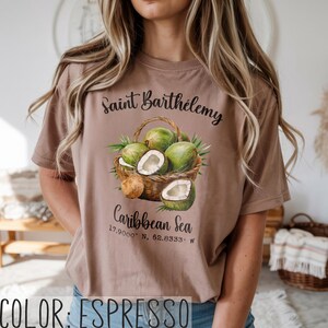 K&ouml;nnte beinhalten: Espressofarbenes T-Shirt mit einem Korb voller gr&uuml;ner Kokosn&uuml;sse und dem Text "Saint Barth&eacute;lemy Caribbean Sea". Das Shirt enth&auml;lt auch die Koordinaten 17.9000&deg; N, 62.8333&deg; W.