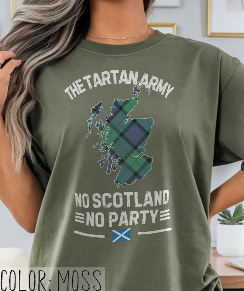 May include: A moss green t-shirt featuring a graphic of the map of Scotland filled with a blue, green, and black tartan pattern. The text reads THE TARTAN ARMY above the map and NO SCOTLAND NO PARTY below, with a small Scottish flag icon at the bottom.