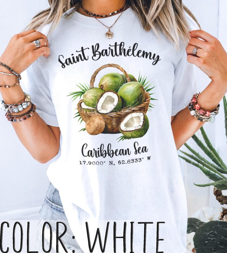 K&ouml;nnte beinhalten: Wei&szlig;es T-Shirt mit einer Grafik eines Korbs mit gr&uuml;nen Kokosn&uuml;ssen, von denen einige halbiert sind, mit dem Text "Saint Barth&eacute;lemy" und "Caribbean Sea". Das Shirt hat auch die Koordinaten 17.9000&deg; N, 62.8333&deg; W und den Text "COLOR: WHITE".