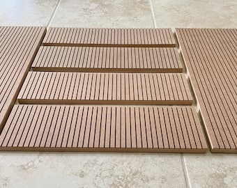 以下が含まれることがあります： 縦溝のある明るい茶色の木製パネルのコレクション。パネルは階段状に配置され、サイズと形状が異なります。木材は自然な木目とマットな仕上がりで、インテリアデザインや建設に適しています。
