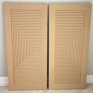 May include: Two wooden panels with a geometric pattern of lines and squares carved into the surface. The panels are light brown and have a natural wood finish.