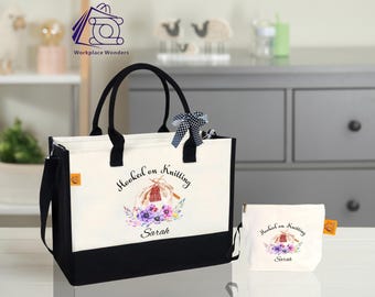 May include: White canvas tote bag with black handles and a black bottom. The bag has a watercolor design of a hand knitting with the text "Hooked on Knitting Sarah". A smaller white canvas pouch with the same design is included.