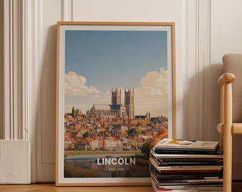 May include: A framed art print featuring a landscape illustration of Lincoln Cathedral rising above a city with red-roofed buildings under a blue sky with clouds. The text LINCOLN ENGLAND is printed in white at the bottom of the image.