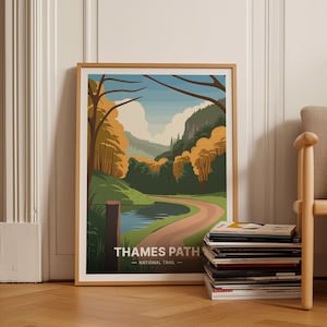 Può includere: Un poster incorniciato con un'illustrazione colorata di un sentiero tortuoso attraverso un bosco con un piccolo lago. Il poster ha il testo "Thames Path - National Trail" in basso.