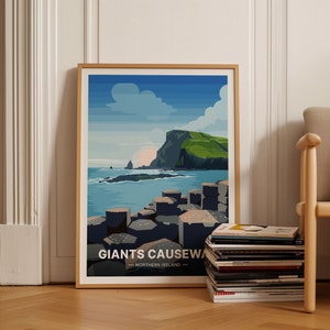 May include: A framed poster with a colorful illustration of the Giant's Causeway in Northern Ireland. The poster features a blue sky with white clouds, a green cliff, and a rocky coastline with hexagonal basalt columns.