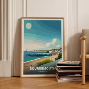 Puede incluir: Una ilustración enmarcada de una ciudad costera con un muelle, una playa y casas. La ilustración es de estilo retro con un cielo azul y nubes blancas. El texto "BOURNEMOUTH - DORSET" está en la parte inferior de la ilustración.
