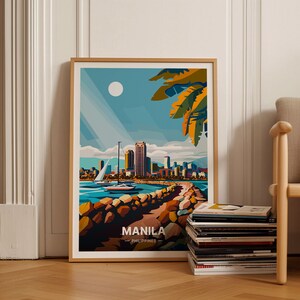 May include: A colorful, geometric illustration of the Manila skyline with a sailboat in the foreground. The illustration is framed in a light wood frame and is set against a white wall. The text "MANILA - PHILIPPINES -" is at the bottom of the illustration.