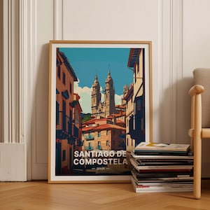May include: A vintage-style poster with a colorful illustration of a street in Santiago de Compostela, Spain. The poster features a view of the city's cathedral with two tall towers and a narrow street lined with buildings.