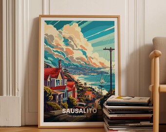 May include: A framed poster with a colorful illustration of a hillside town in Sausalito, California. The poster features a vibrant blue sky with fluffy clouds, a winding road, and a view of the bay. The text "Sausalito - California" is printed at the bottom of the poster.
