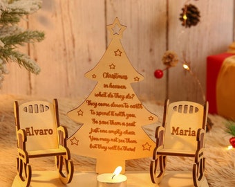 Puede incluir: Un adorno de árbol de Navidad de madera con dos mecedoras, una con la etiqueta "Alvaro" y la otra "Maria". El árbol tiene una estrella en la parte superior y el texto "Navidad en el cielo, ¿qué hacen? Bajan a la tierra para pasarlo contigo. Así que resérvales un asiento. Solo una silla vacía. Puede que no los veas, pero estarán ahí!"