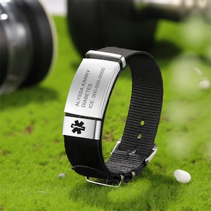 May include: Black medical alert bracelet with a silver engraved tag that reads "ALYSSA KERRY DIABETES ICE: 000-000-0000". The tag also features a medical symbol.