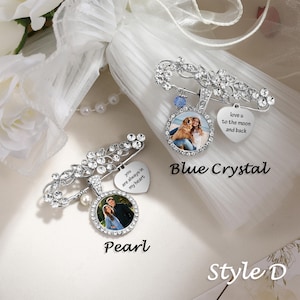 May include: Two silver-toned brooch pins featuring clear rhinestones, circular photo pendants, and heart-shaped charms. One pin includes a blue crystal and text reading love u to the moon and back, while the other has a pearl and text reading you are always in my heart.