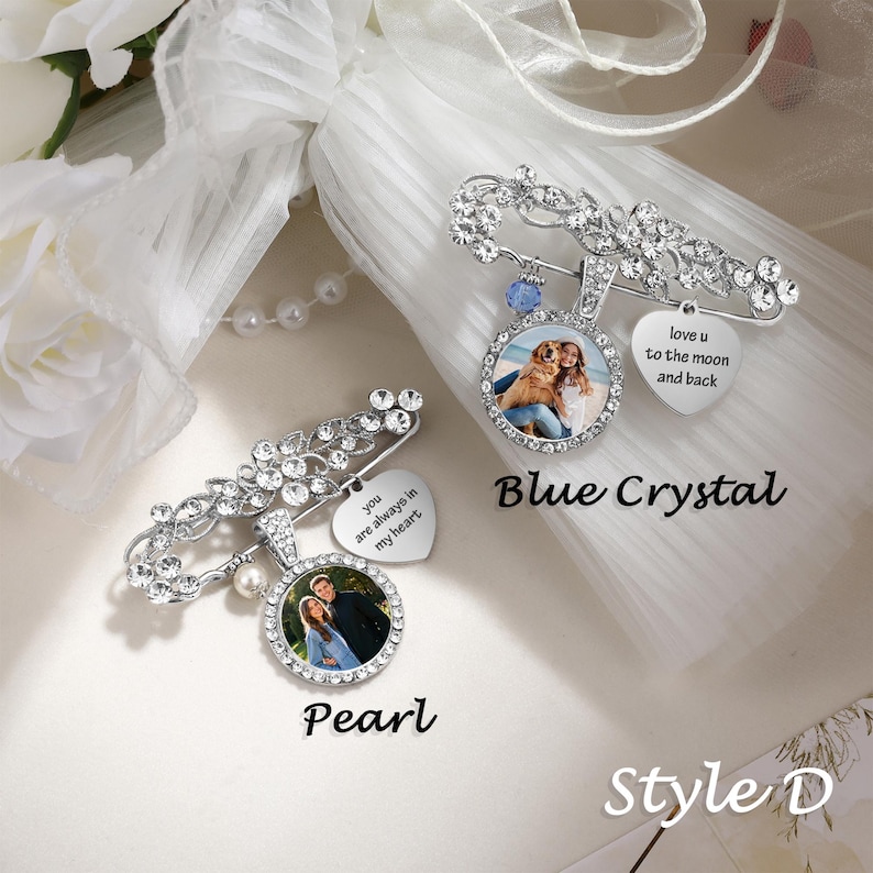 May include: Two silver-toned brooch pins featuring clear rhinestones, circular photo pendants, and heart-shaped charms. One pin includes a blue crystal and text reading love u to the moon and back, while the other has a pearl and text reading you are always in my heart.