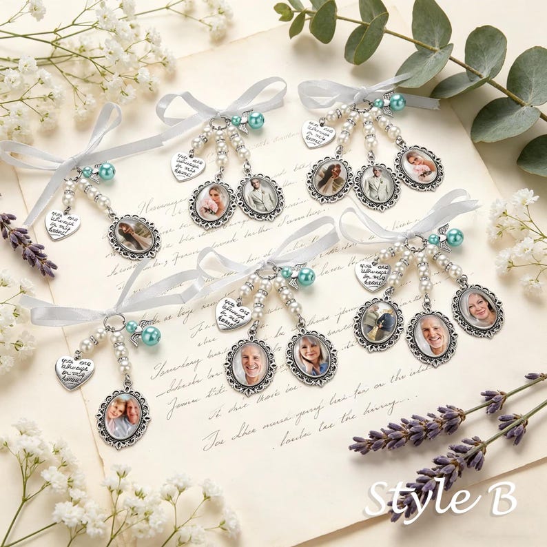 May include: Five silver-toned photo charms featuring oval frames with portraits, white ribbon bows, pearl-like beads, teal accent beads, and heart-shaped metal tags engraved with the text You are always in my heart, arranged on a paper background.
