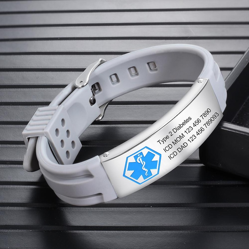 May include: Gray silicone medical alert bracelet with a silver buckle and a white medical symbol. The bracelet has the text "Type 2 Diabetes", "ICD MOM 123 456 7890", and "ICD DAD 123 456 789093".