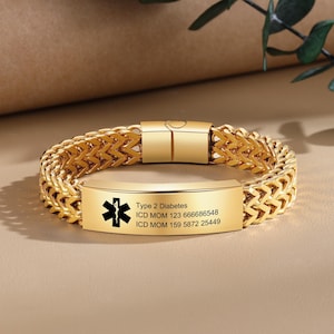 May include: Gold medical ID bracelet with a black medical symbol and text that reads "Type 2 Diabetes, ICD MOM 123 666686548, ICD MOM 159 5872 25449".