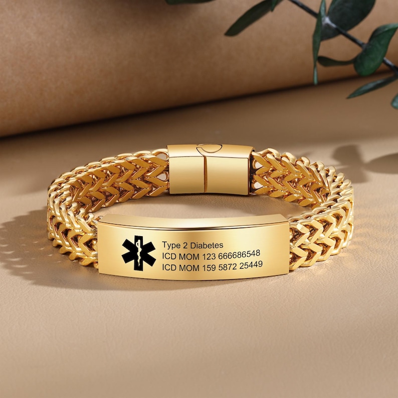 May include: Gold medical ID bracelet with a black medical symbol and text that reads "Type 2 Diabetes, ICD MOM 123 666686548, ICD MOM 159 5872 25449".