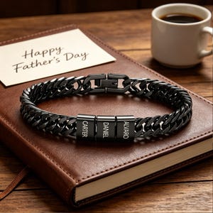 Puede incluir: Una pulsera de eslabones de metal negro con tres cuentas rectangulares grabadas con los nombres Carter, Daniel y Alvaro. La pulsera cuenta con un cierre seguro y un acabado pulido, presentando un dise&ntilde;o audaz y resistente para el uso diario.
