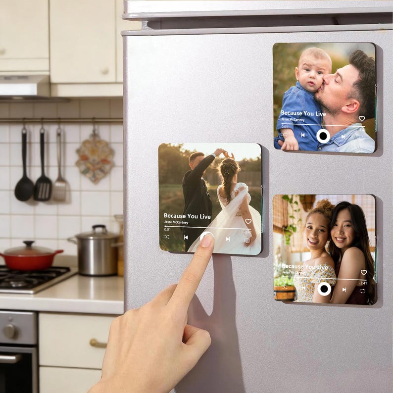 K&ouml;nnte beinhalten: Drei quadratische K&uuml;hlschrankmagnete mit individuellen Fotodrucken, die wie Musik-Player-Oberfl&auml;chen gestaltet sind. Jeder Magnet zeigt einen Songtitel, K&uuml;nstlernamen und Wiedergabesteuerungen mit Bildern eines Paares, eines Elternteils und Kindes.