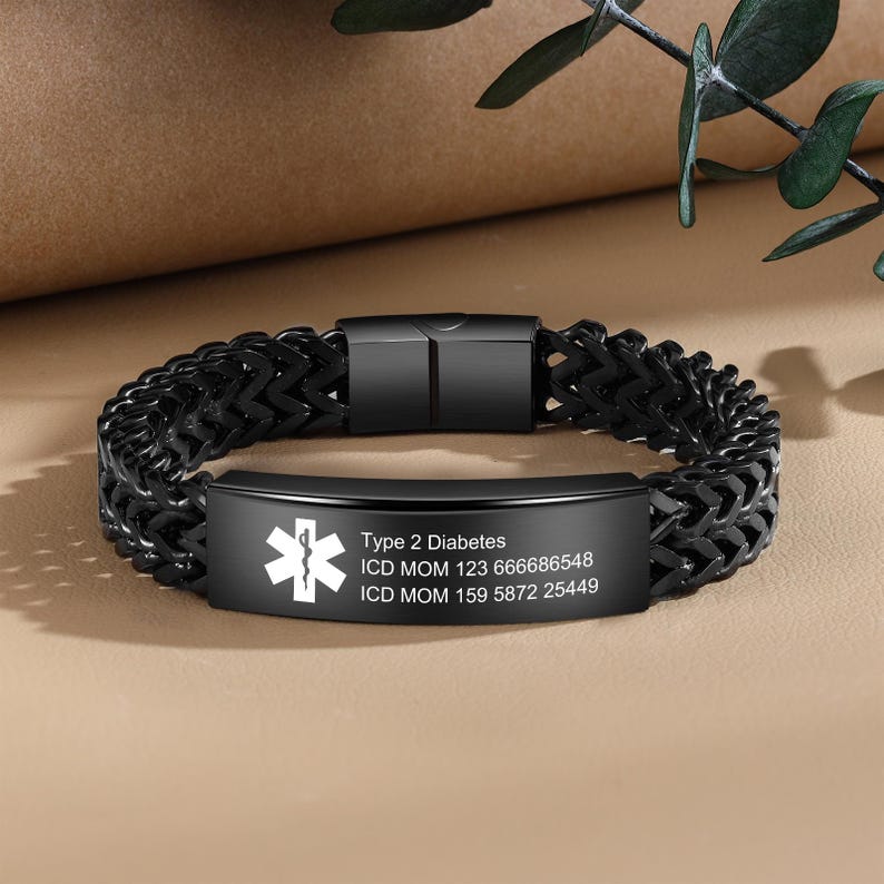 May include: Black medical alert bracelet with a stainless steel chain and a silver plate engraved with "Type 2 Diabetes", "ICD MOM 123 666686548", and "ICD MOM 159 5872 25449".