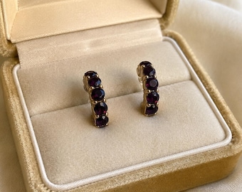 Pendientes de aro vintage con cristales morados en tono dorado.
