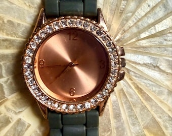 Reloj nuevo sin etiquetas con bisel de cristal color oro rosa y correa de silicona verde bosque.