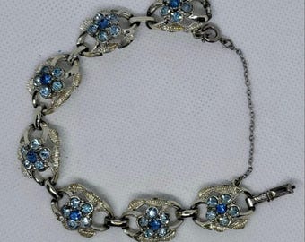Pulsera vintage Coro azul con pedrería y eslabones florales, cadena de seguridad plateada.