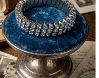 Pulsera elástica vintage de los años 50 con pedrería azul y acabado plateado glamuroso.