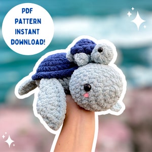 May include: A crocheted blue and gray turtle amigurumi toy with a smaller blue turtle on its back. The text "PDF PATTERN INSTANT DOWNLOAD!" is in a white circle on the left side of the image.