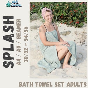 May include: A woman wearing a light blue bath towel sits on a sandy beach. The towel is wrapped around her waist and she is wearing a pink turban on her head. The text "SPLASH" is in large, bold letters on the left side of the image. The text "A4/AO/BEAMER 30/32-54/56 BATH TOWEL SET ADULTS" is on the right side of the image.