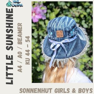 May include: A blue denim sun hat with a frayed edge, decorated with light blue floral embroidery and a white ribbon. The hat has a small leather patch and is designed for girls and boys. The text on the hat reads "LITTLE SUNSHINE" and "SONNENHUT GIRLS & BOYS".