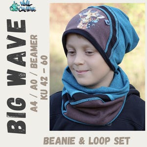 May include: A teal beanie and loop scarf set. The beanie has a giraffe graphic with sunglasses on a brown panel. The set includes black trim and light blue stitching. The text "BIG WAVE" and "BEANIE & LOOP SET" are visible.