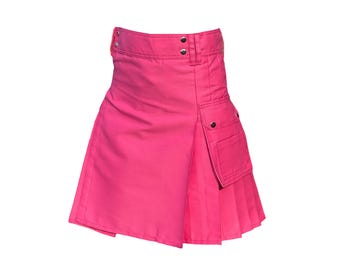 Könnte beinhalten: Ein leuchtend pinkfarbener Rock im Kilt-Stil mit plissierter Vorderseite und Wickeldesign. Er hat zwei Taschen mit Knopfverschlüssen und einen Bund mit zwei silbernen Knöpfen. Der Rock ist aus einem einfarbigen Stoff gefertigt.