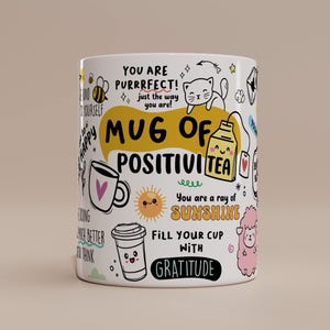 Puede incluir: Taza de cerámica blanca con ilustraciones y texto coloridos. La taza presenta una abeja, un gato, un sol y otros dibujos, junto con frases como "Mug of PositiviTEA" y "Fill your cup with gratitude."