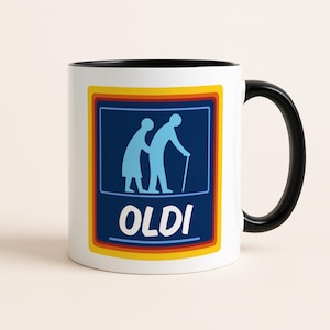 Puede incluir: Taza de cerámica blanca con asa e interior negros. La taza presenta un gráfico azul, amarillo y naranja con la palabra "OLDI" y siluetas de dos ancianos. Un regalo humorístico.