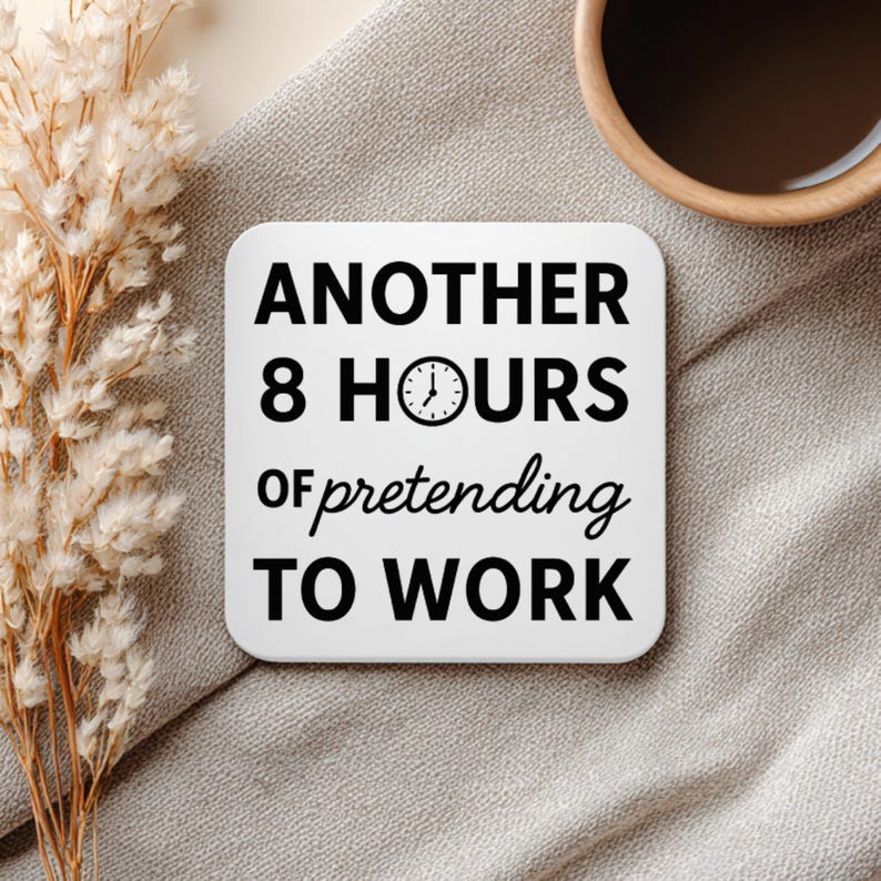 K&ouml;nnte beinhalten: Wei&szlig;er quadratischer Untersetzer mit dem Text "ANOTHER 8 HOURS of pretending TO WORK" in Schwarz. Eine Uhrgrafik befindet sich in der Mitte des Textes. Der Untersetzer liegt auf einer grauen Oberfl&auml;che mit Trockenblumen und einer Kaffeetasse im Hintergrund.