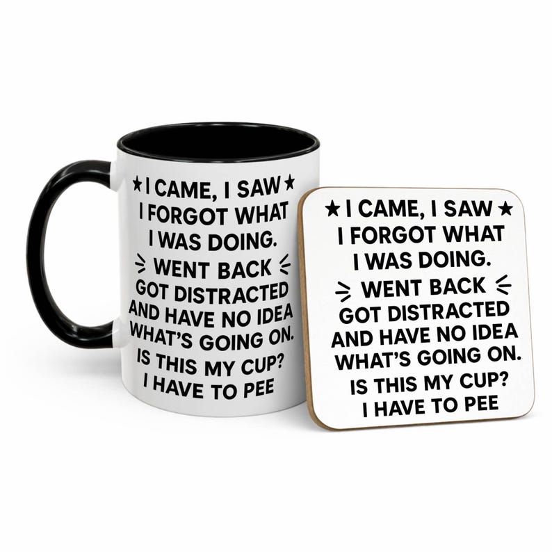 K&ouml;nnte beinhalten: Eine wei&szlig;e Keramiktasse mit schwarzem Henkel und Rand sowie ein passender Untersetzer. Beide Artikel zeigen den Text "I CAME, I SAW, I FORGOT WHAT I WAS DOING" in Schwarz, mit einer Stern-Grafik.