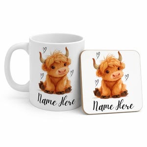 Pode incluir: Uma caneca branca e uma base quadrada com uma ilustra&ccedil;&atilde;o de uma vaca das Terras Altas. A vaca &eacute; laranja com pequenos chifres e cora&ccedil;&otilde;es. O texto "Name Here" est&aacute; abaixo da vaca em ambos os itens.