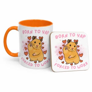 May include: A white ceramic mug with an orange interior and handle, and a matching square coaster. Both feature a cartoon hamster with a peace sign, surrounded by hearts, and the text "BORN TO YAP FORCED TO WORK."